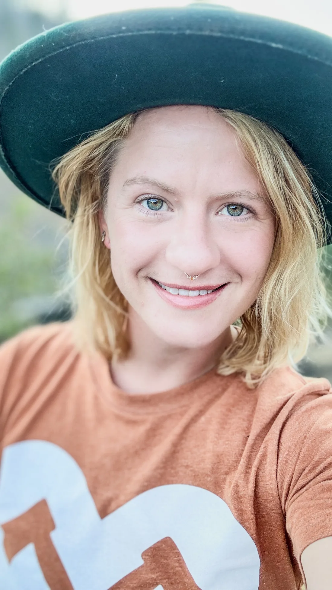 Sasha smiling in her wide-brimmed green hat